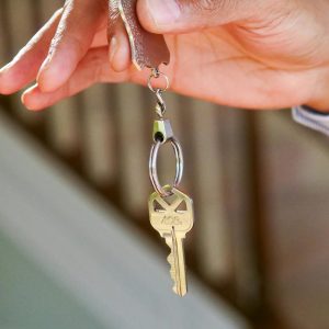 Close-up of a hand holding a key, symbolizing new homeownership or rental.